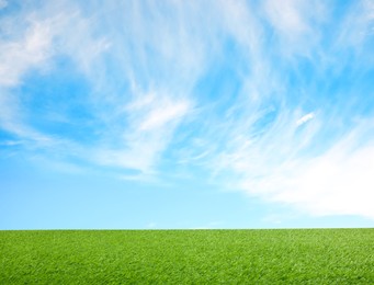 Image of Green grass under blue sky with clouds