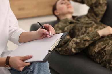 Photo of Psychotherapist working with military woman in office