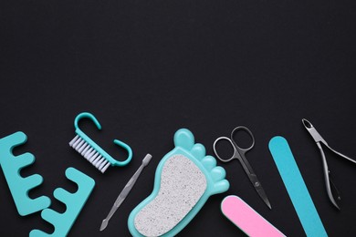 Photo of Set of pedicure tools on black background, flat lay. Space for text