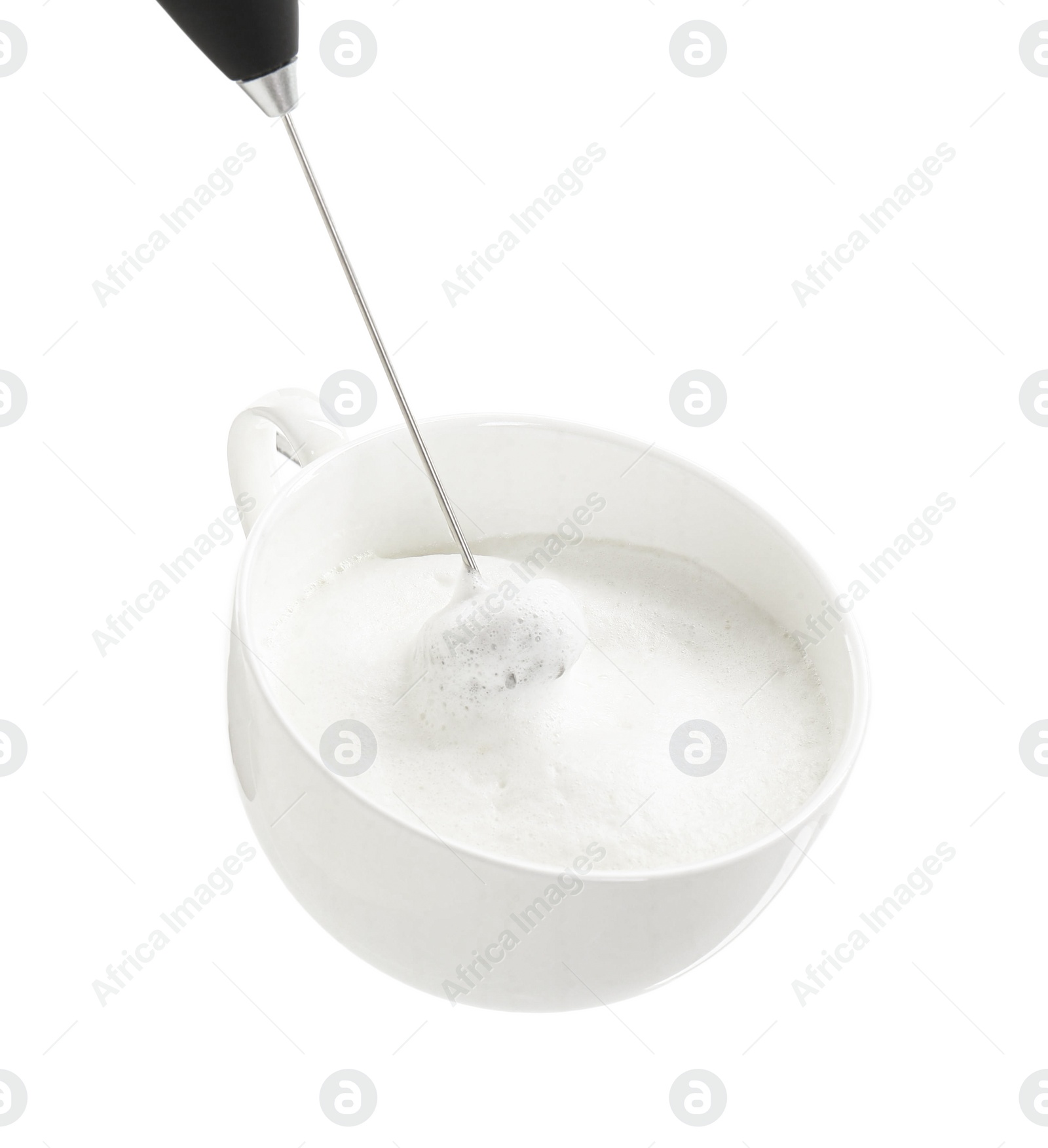 Photo of Whisking milk in cup with mini mixer (frother wand) isolated on white, closeup