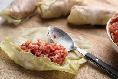 Preparing stuffed cabbage rolls on wooden board, closeup