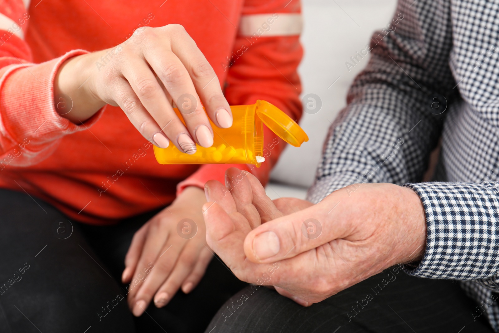 Photo of Woman giving pills to senior man, closeup