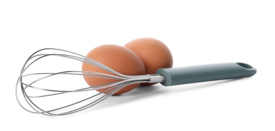 Photo of Whisk and raw eggs isolated on white