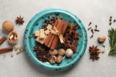 Different aromatic spices and fir branches on light textured table, flat lay