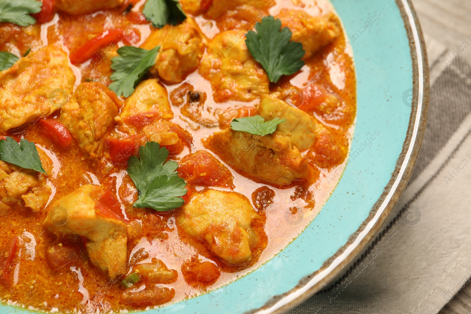 Photo of Delicious chicken curry with parsley on table, closeup