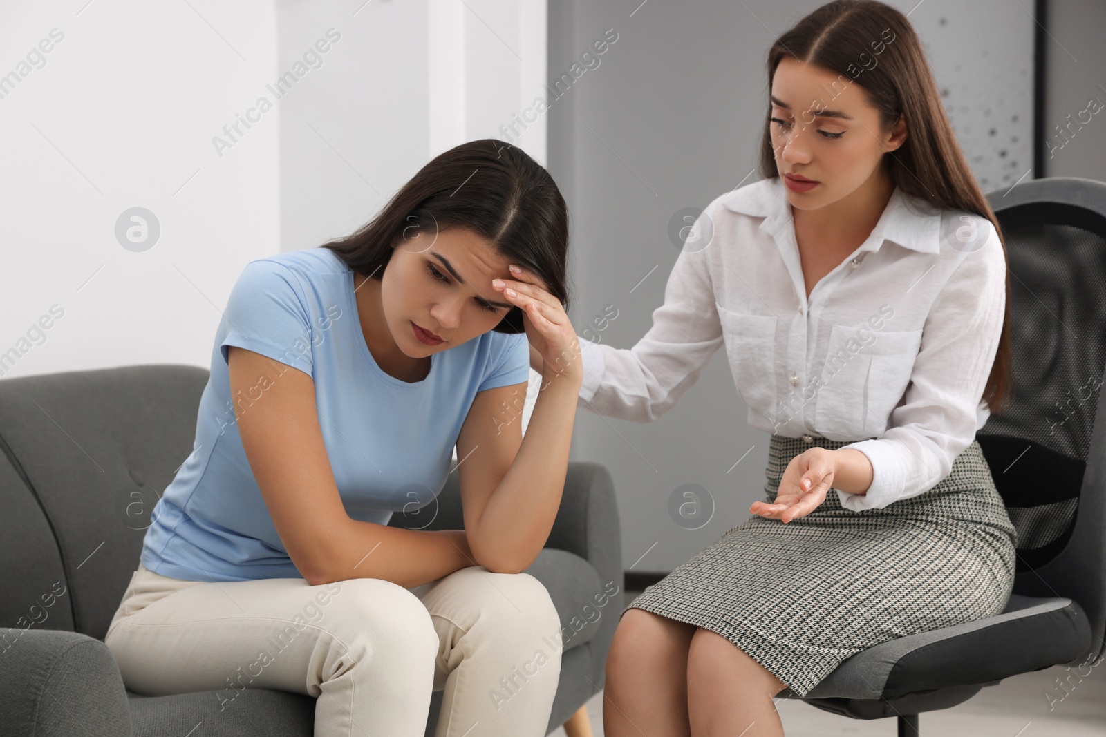 Photo of Professional psychologist working with young woman in office