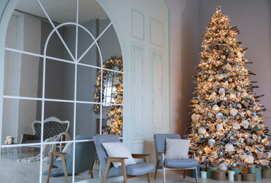 Festive room interior with stylish furniture and beautiful Christmas tree