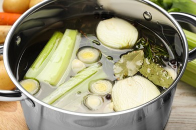 Different ingredients for cooking tasty bouillon in pot on table, closeup