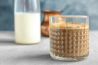 Glass of aromatic hot coffee on table