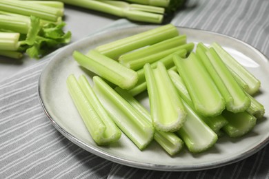 Fresh green cut celery on striped tablecloth, closeup