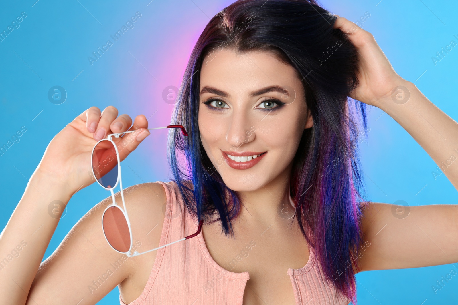 Photo of Young woman with bright dyed hair on color background