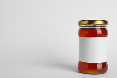 Glass jar of wildflower honey with blank label isolated on white