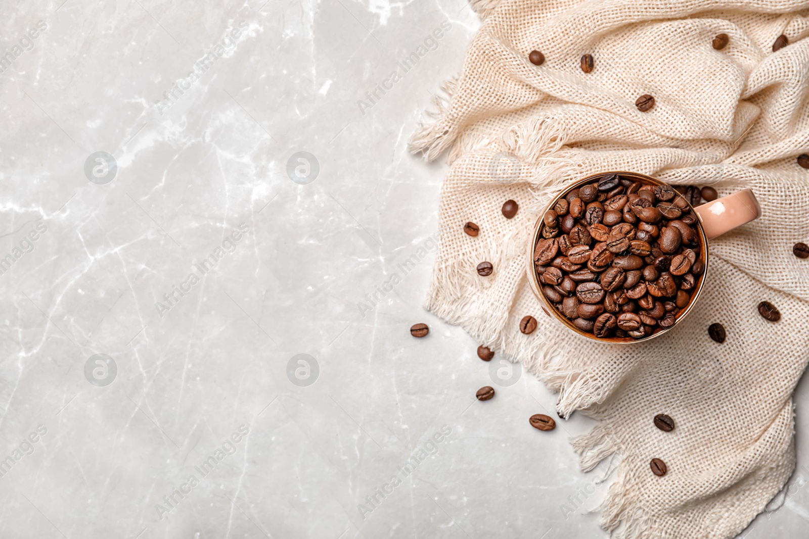 Photo of Ceramic cup with coffee beans on light background, top view