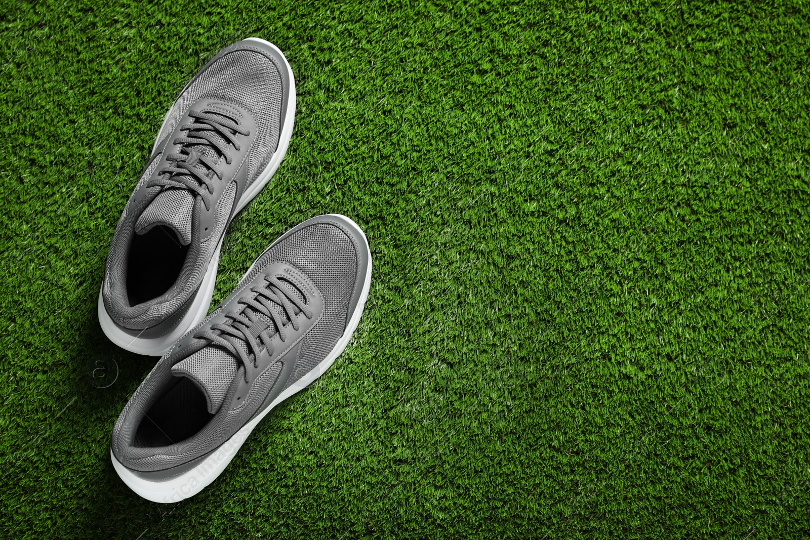 Photo of Pair of stylish sport shoes on green grass, flat lay. Space for text
