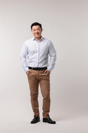 Photo of Full length portrait of happy man on light background