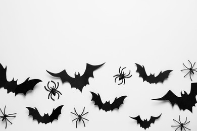 Flat lay composition with paper bats and spiders on white background, space for text. Halloween celebration