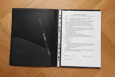 Photo of File folder with punched pocket and document on wooden table, top view