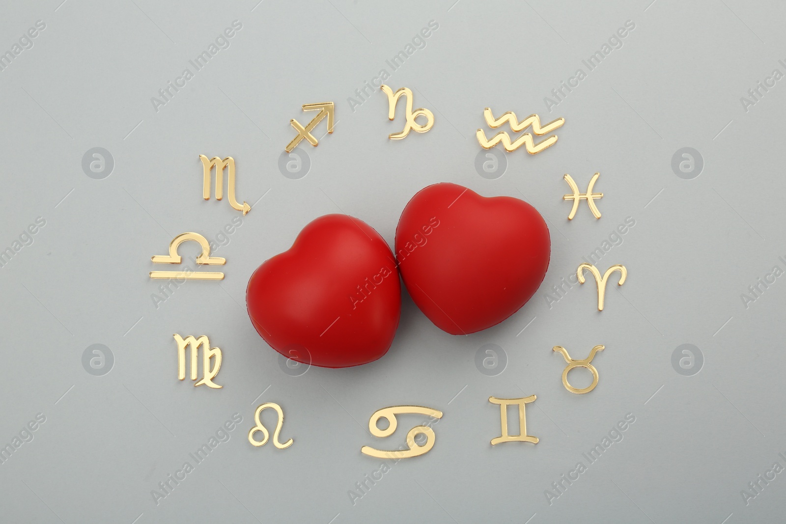 Photo of Zodiac signs and red hearts on grey background, flat lay