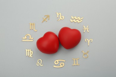 Photo of Zodiac signs and red hearts on grey background, flat lay