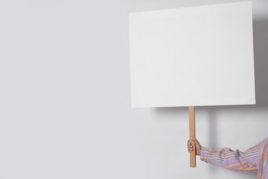 Photo of Woman holding blank sign on white background, closeup