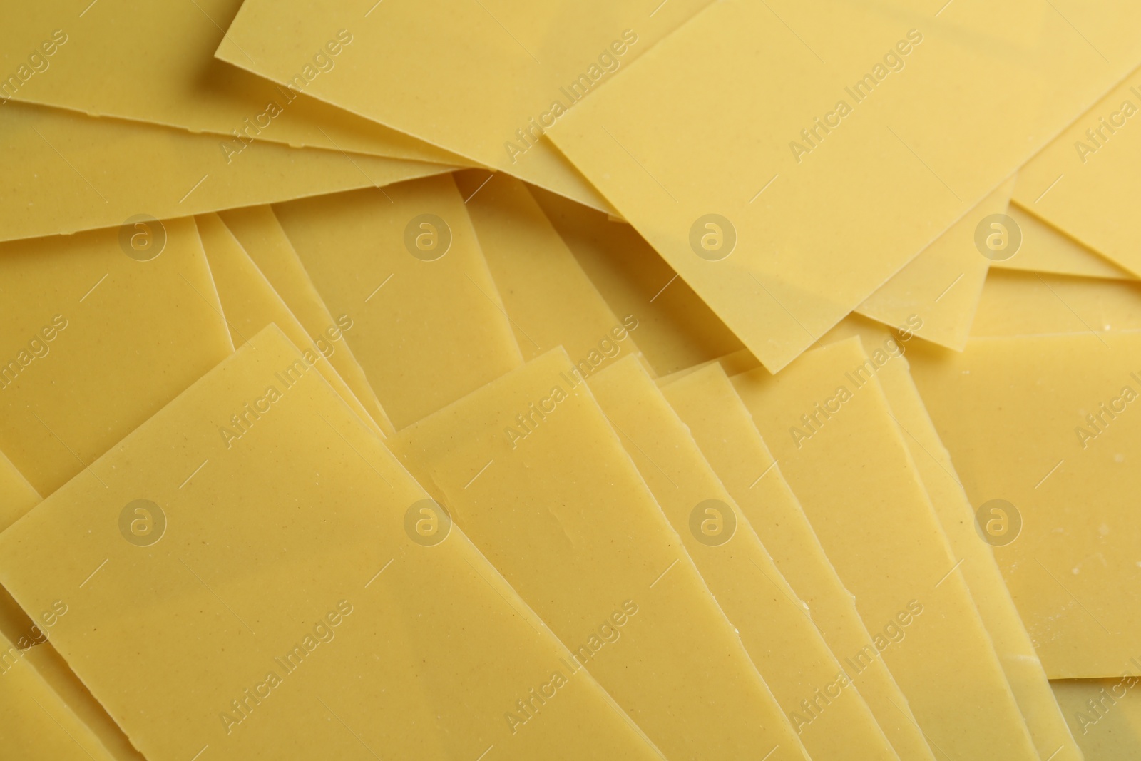 Photo of Pile of dry lasagna sheets as background, closeup