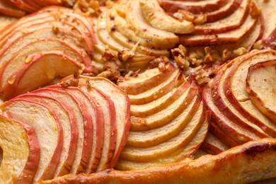 Photo of Fresh apple galette with nuts as background, closeup