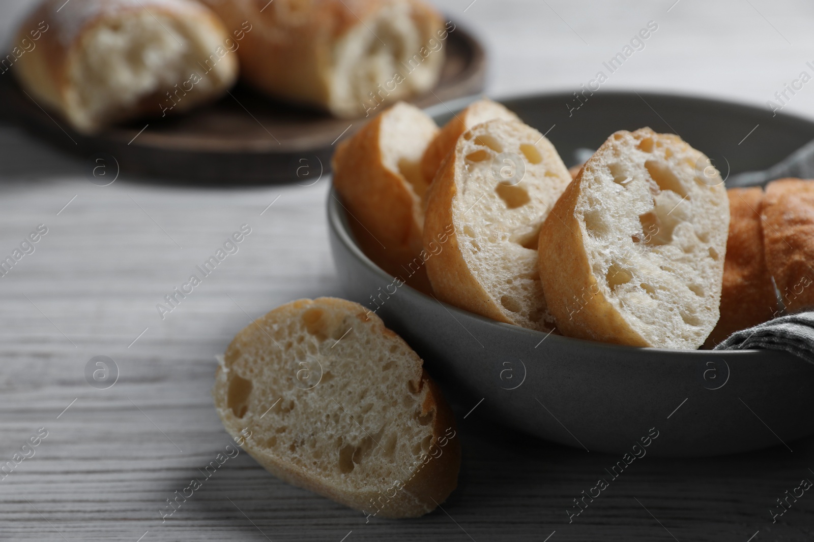 Photo of Fresh crispy ciabattas on white wooden table. Space for text
