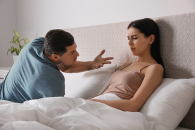 Photo of Couple quarreling in bed at home. Relationship problems
