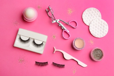 Photo of Flat lay composition with magnetic eyelashes and accessories on crimson background