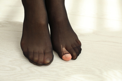 Woman wearing torn tights at home, closeup