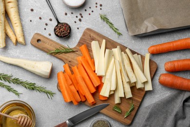 Flat lay composition with parsnips, carrots and other products on light grey table