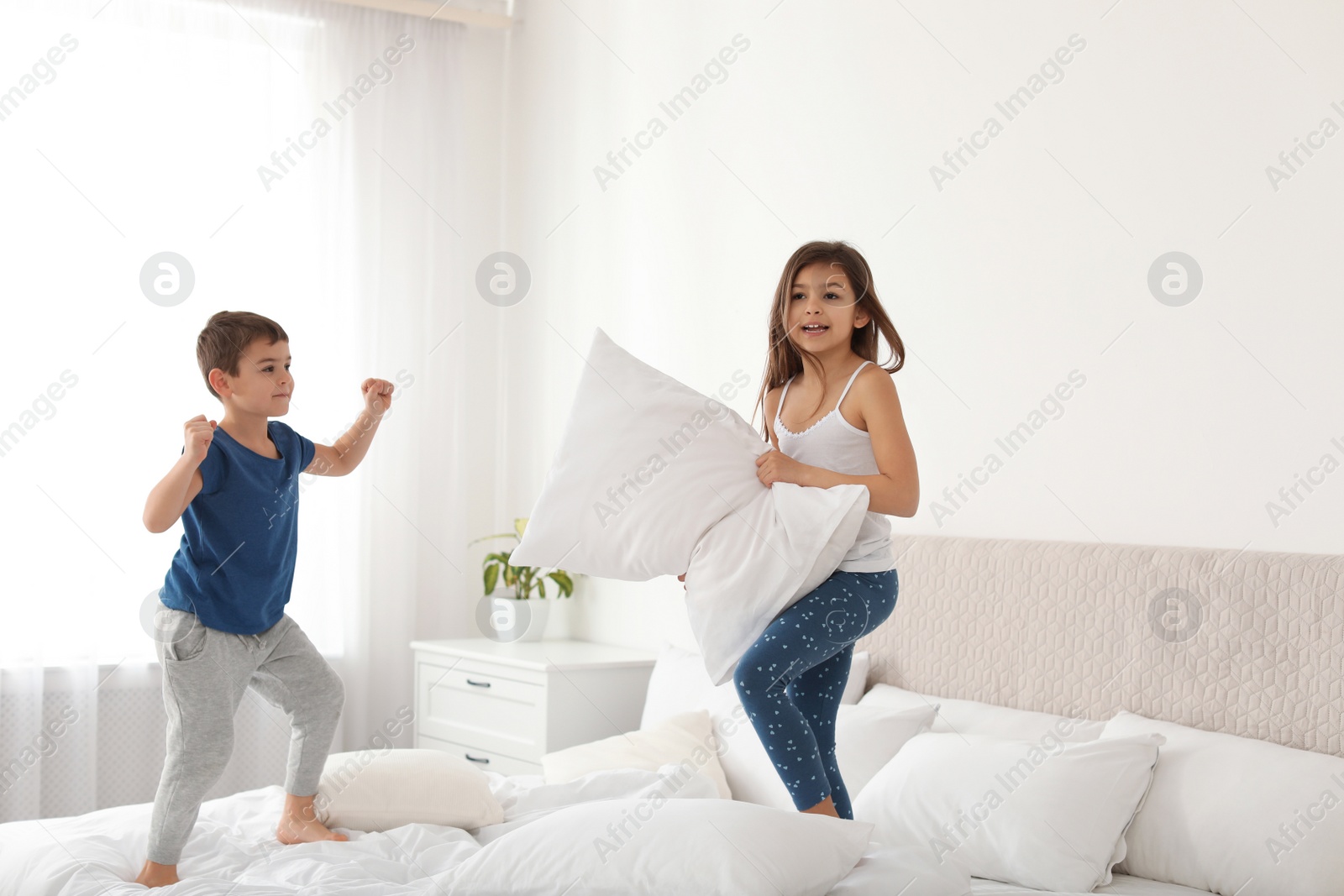Photo of Happy children having pillow fight in bedroom