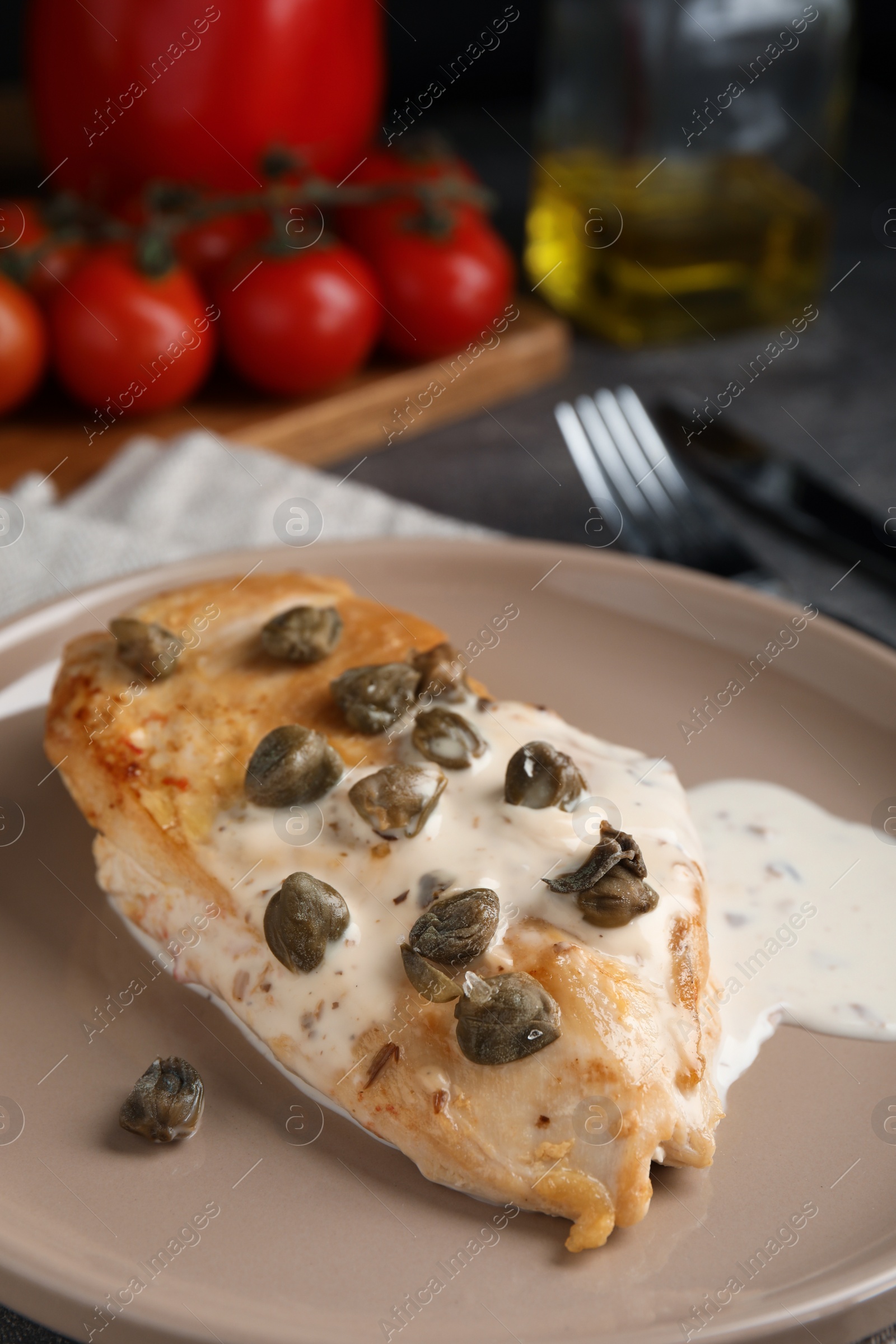 Photo of Delicious chicken fillet with capers and sauce on plate, closeup