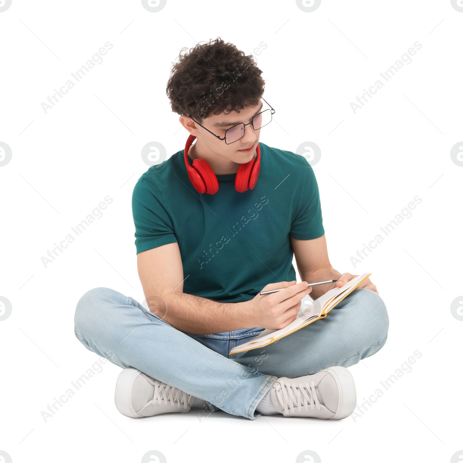 Photo of Portrait of student with notebook and headphones sitting on white background