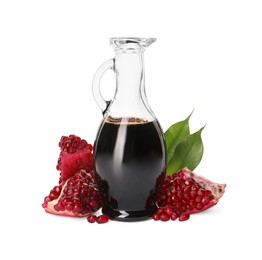 Glass jug of pomegranate sauce and fresh ripe fruit on white background