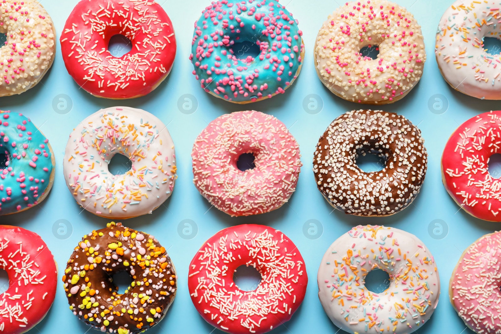 Photo of Delicious glazed doughnuts on color background, top view