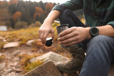 Photo of Man with thermo tumbler in nature, closeup. Space for text