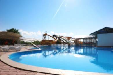 Photo of Blurred view of water park with swimming pool. Summer vacation