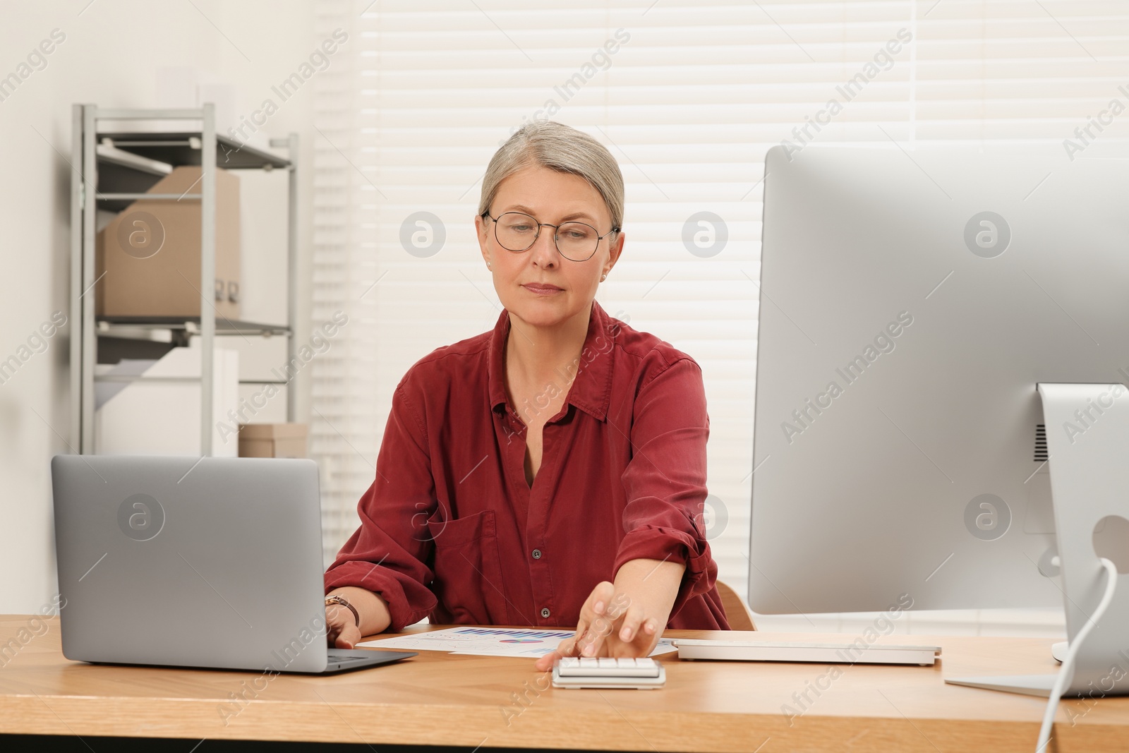 Photo of Senior accountant working at wooden desk in office