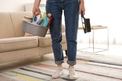 Woman with basket of professional cleaning products indoors, closeup