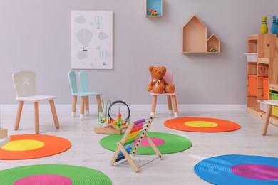 Photo of Child`s playroom with different toys and furniture. Cozy kindergarten interior