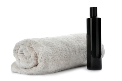 Rolled towel and shampoo isolated on white