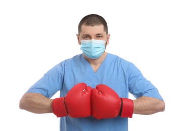 Photo of Doctor with protective mask and boxing gloves on white background. Strong immunity concept
