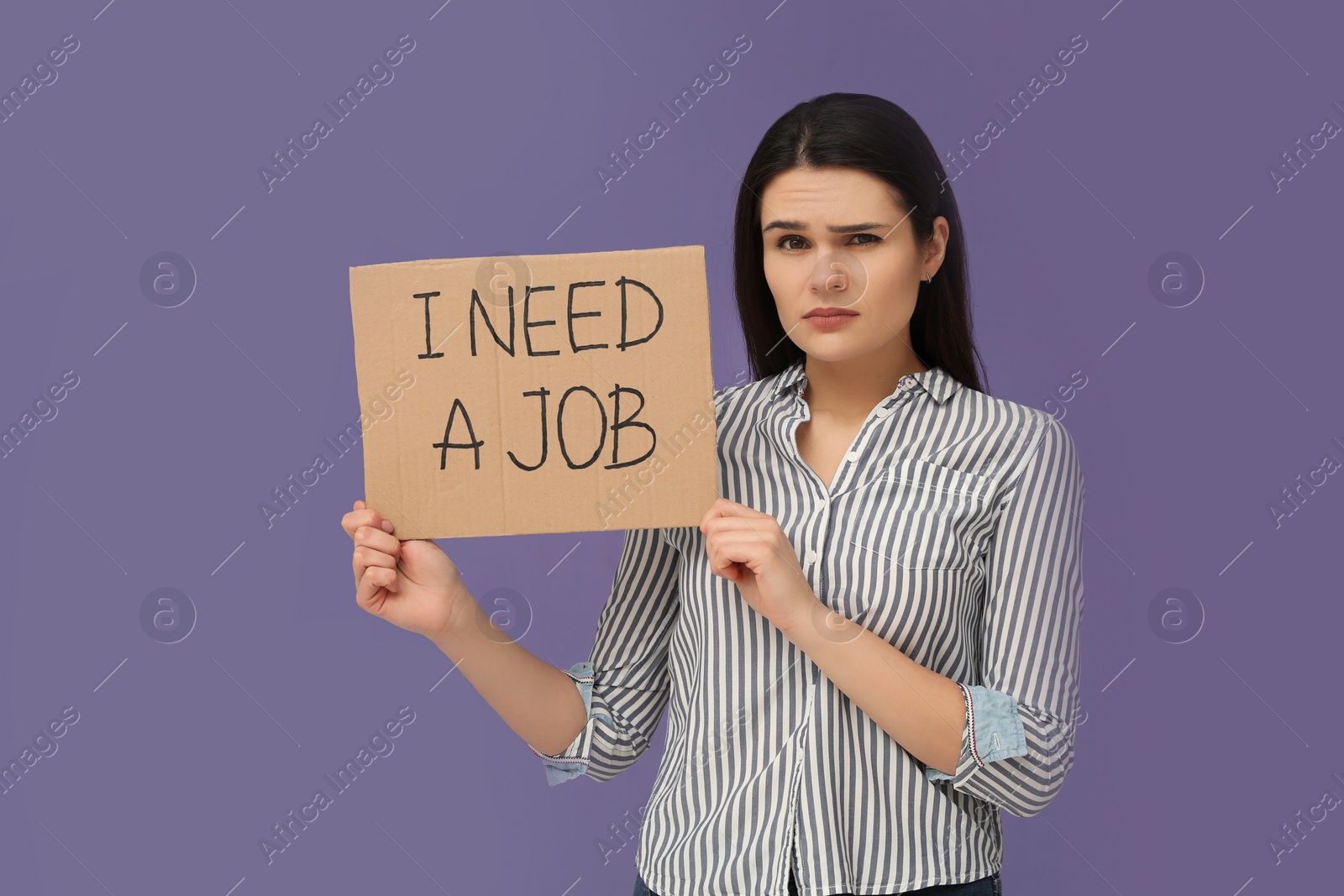 Photo of Unemployment problem. Unhappy woman holding sign with phrase I Need A Job on violet background