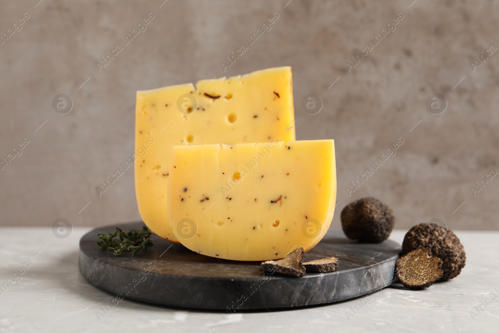 Photo of Fresh cheese and truffles on grey table