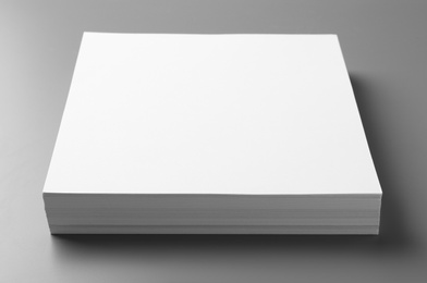 Stack of blank paper sheets for brochure on grey background. Mock up