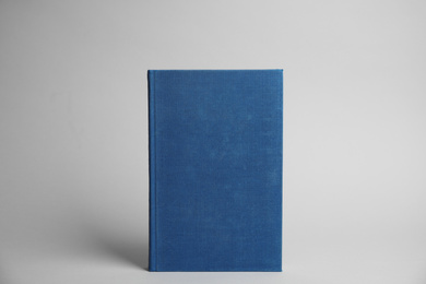 Hardcover book on light grey background. Space for design