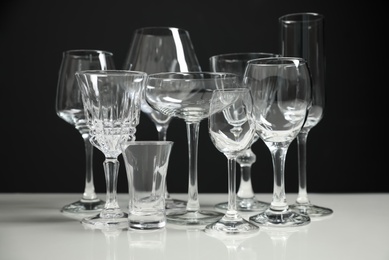 Photo of Set of bar glassware on white table against black background