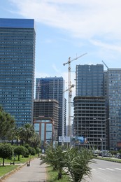 Photo of Batumi, Georgia - June 06, 2022: View of construction site with tower cranes near unfinished and modern buildings outdoors