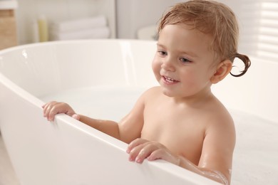 Photo of Cute little girl taking bath at home